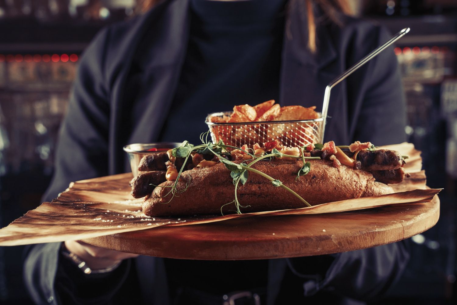 Servitør bærer pubmat på en trefjøl